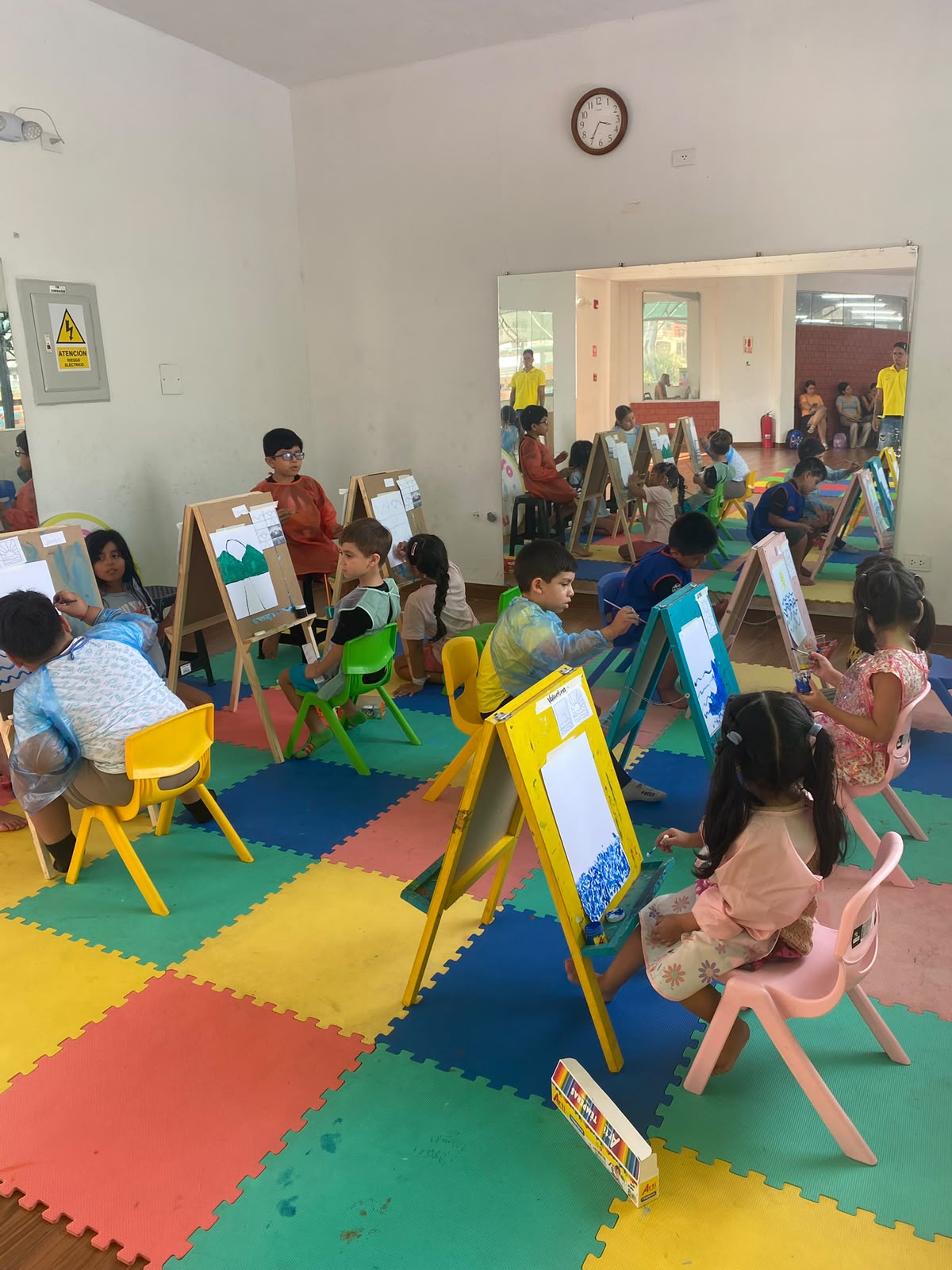 Clase de pintura con caballetes para niños